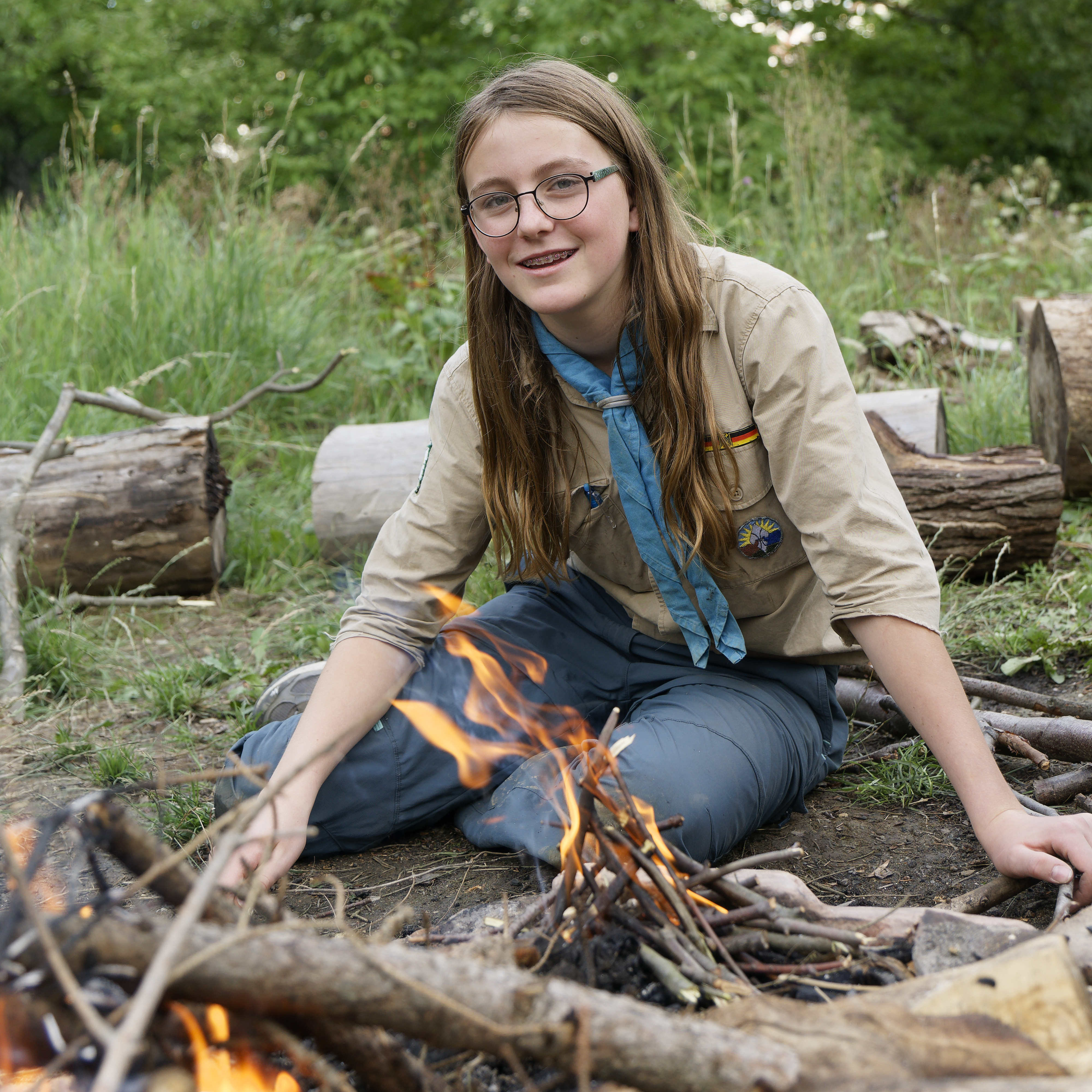 Eine Pfadfinderin schürt ein Feuer