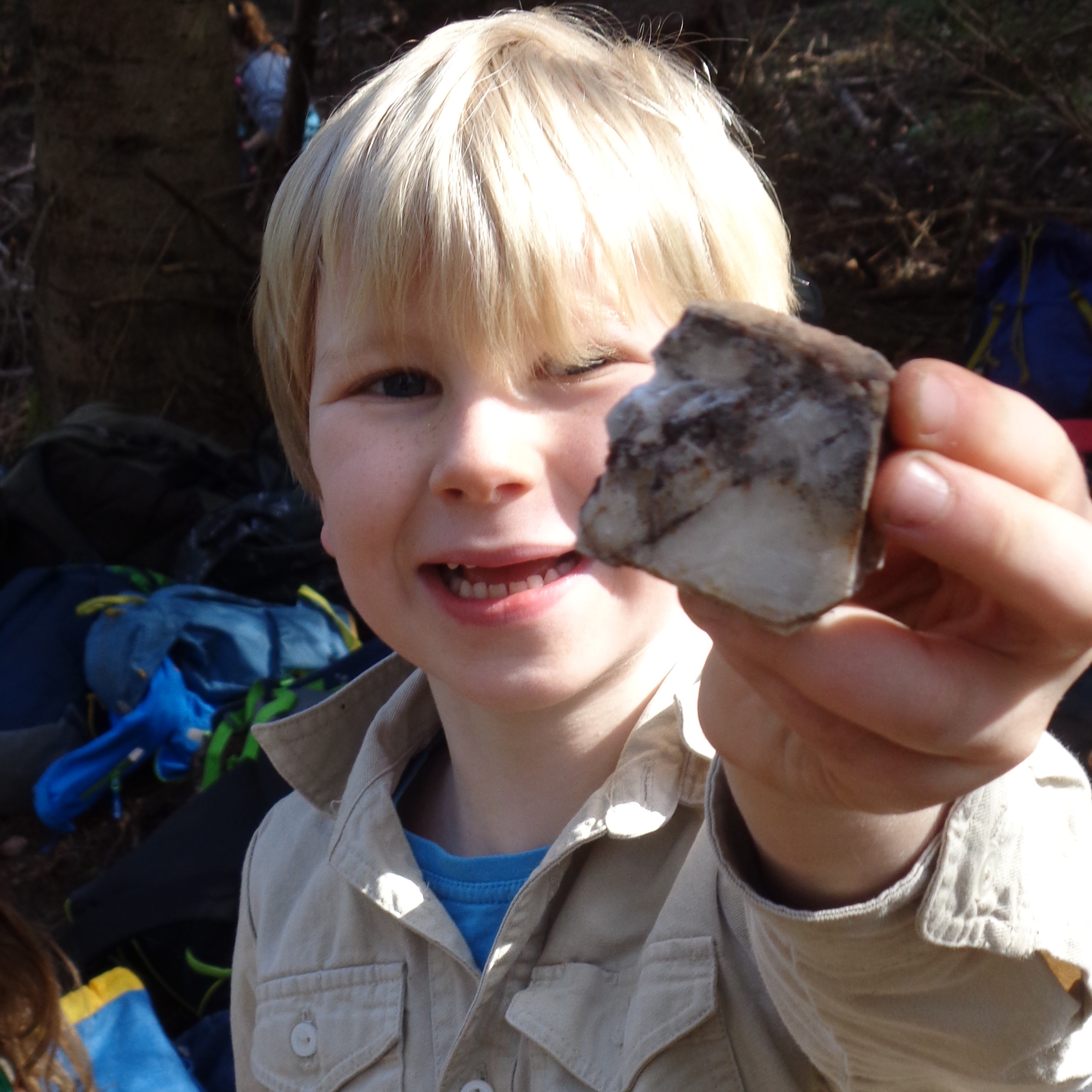 Ein junger Pfadfinder lacht in die Kamer un dzeigt seinen Schwerspat