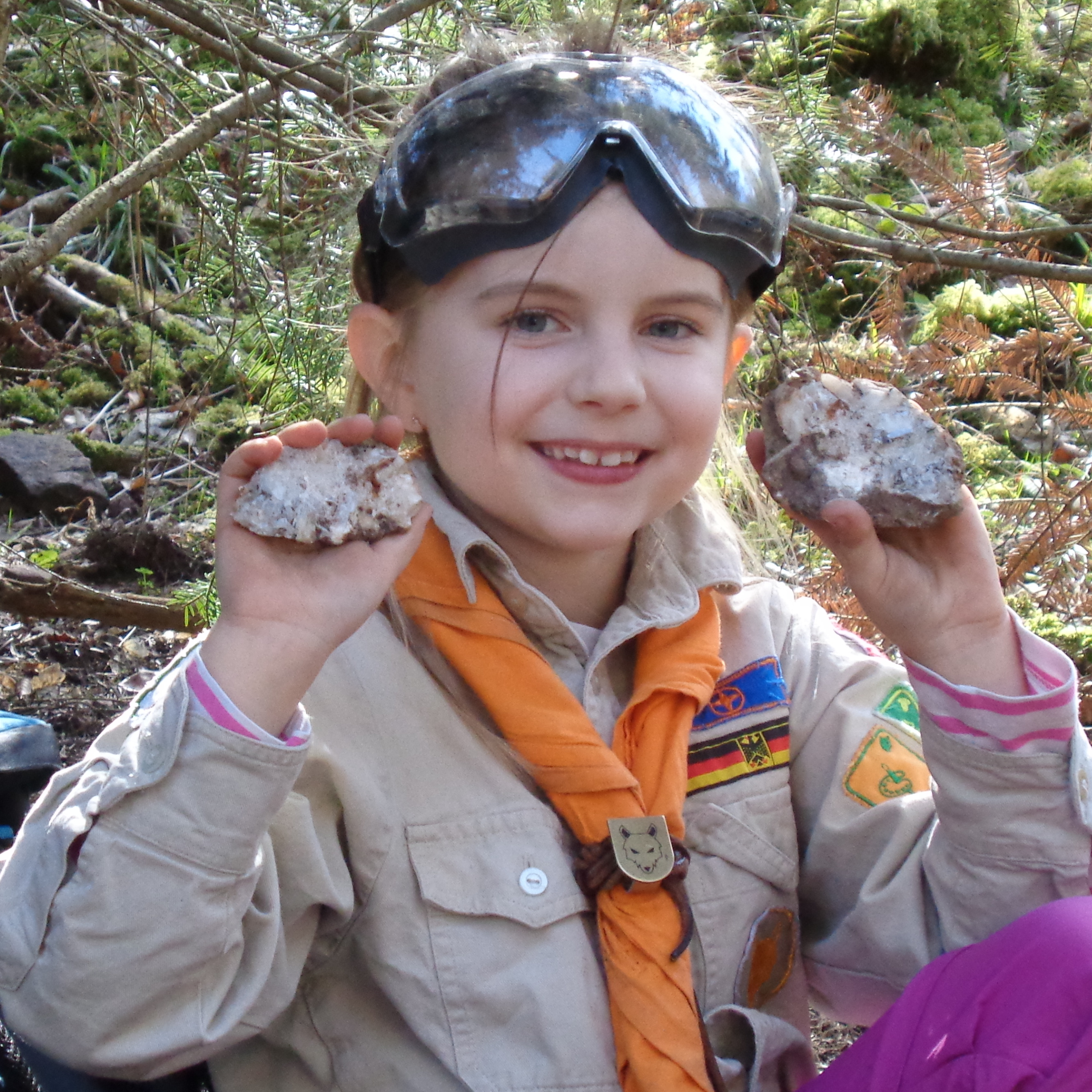 Mädchen lacht in die Kamera mit dem selbst gespaltenen Stein