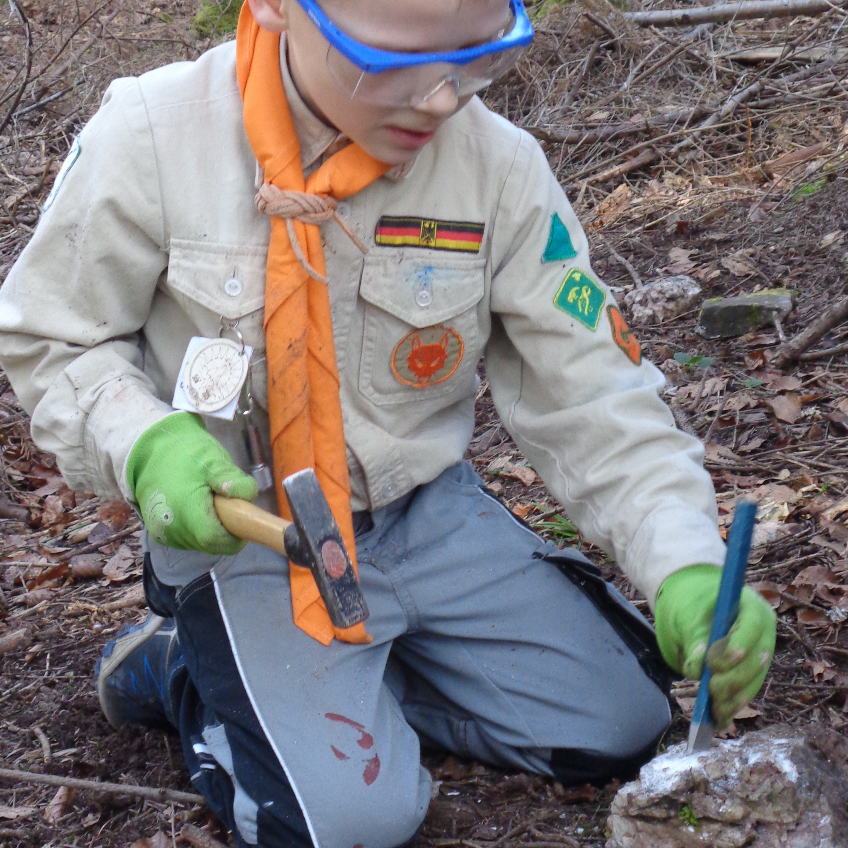 Ein Junge arbeitet mit Schutzausrüstung an den Gesteinen