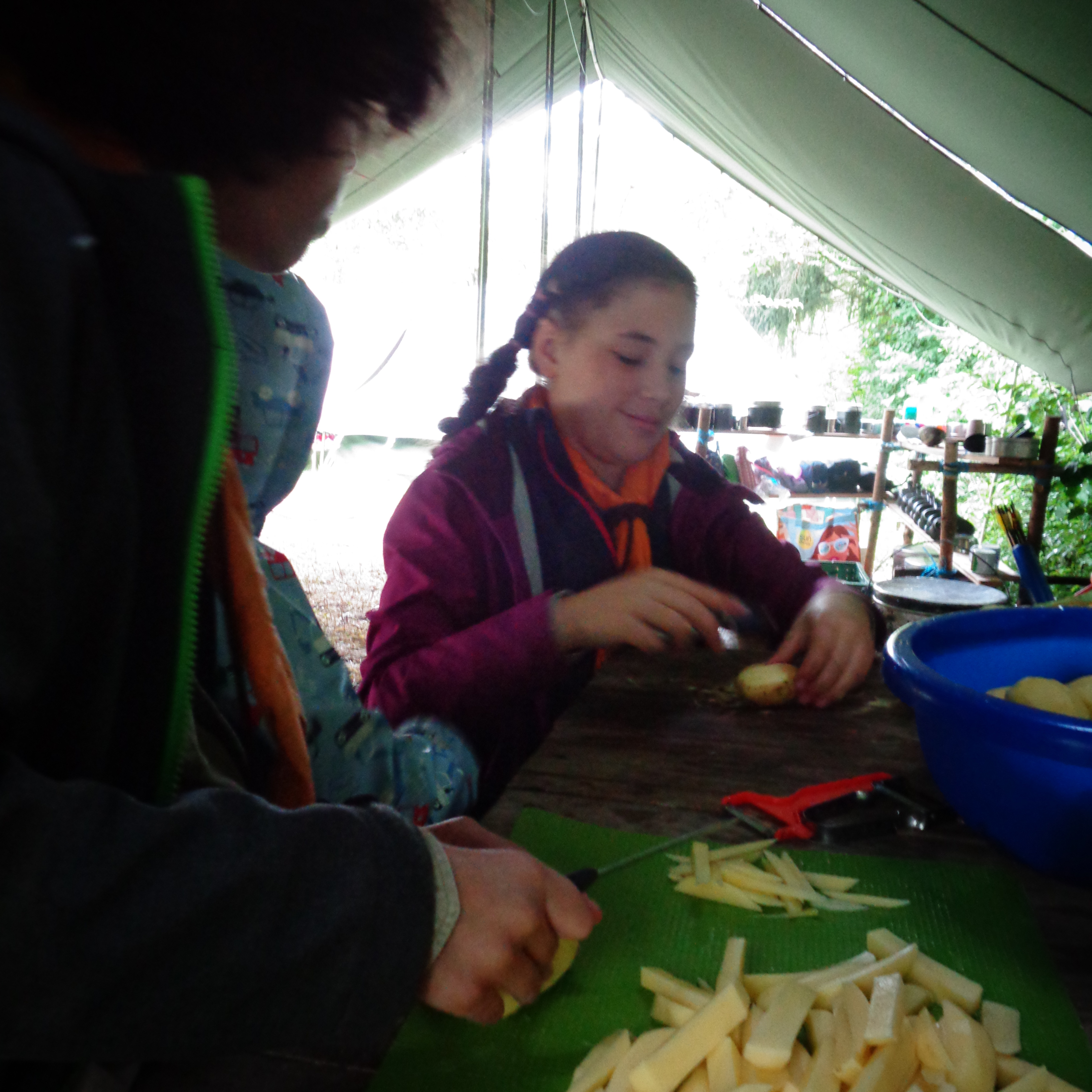Zwei Kinder schälen und schneiden Kartoffeln für selbstgemachte Pommes