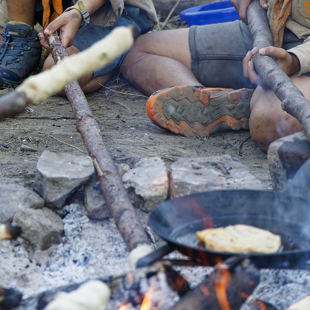 Ein Lagerfeuer mit Stockbroten darüber.