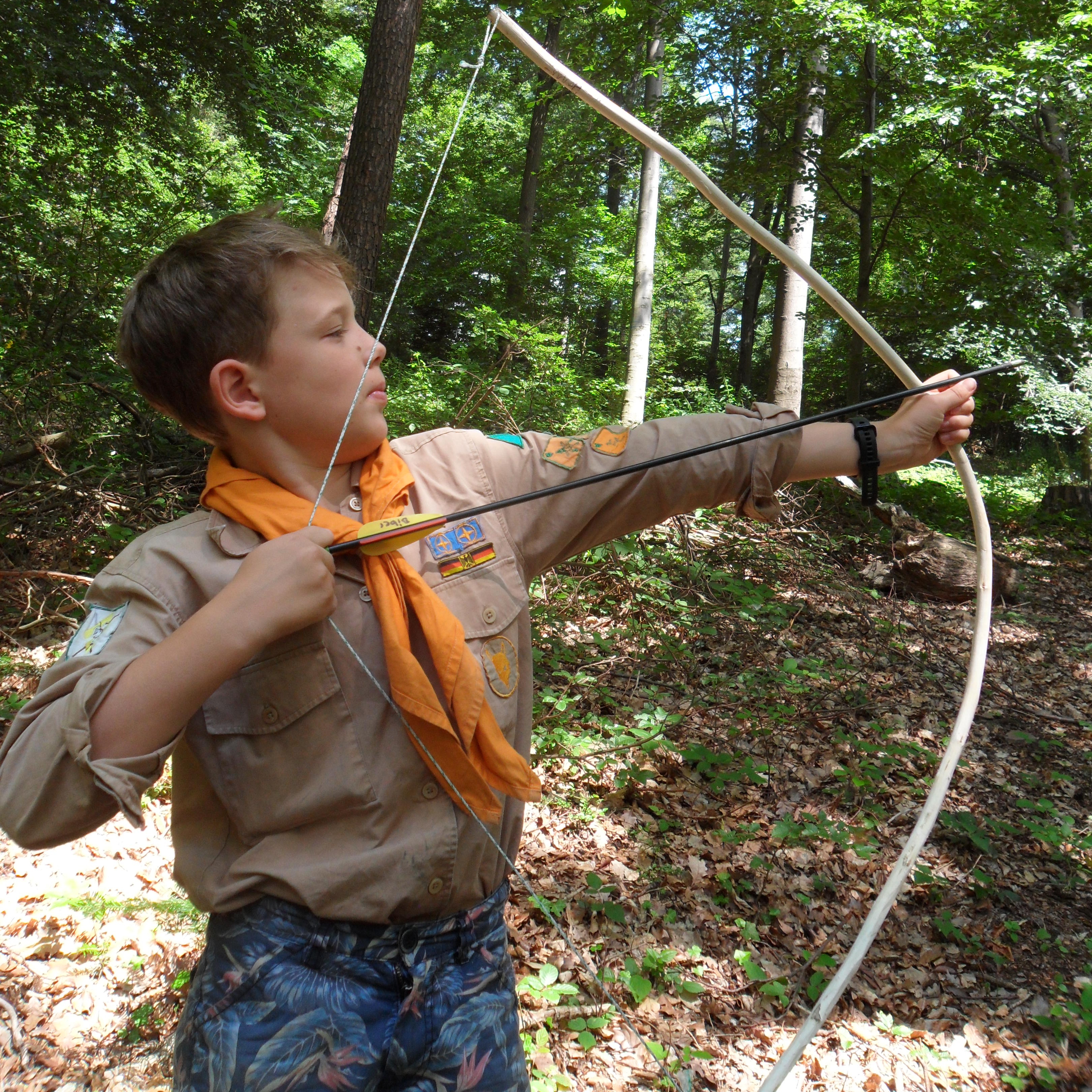 Ein Junge spannt Pfeil und Bogen
