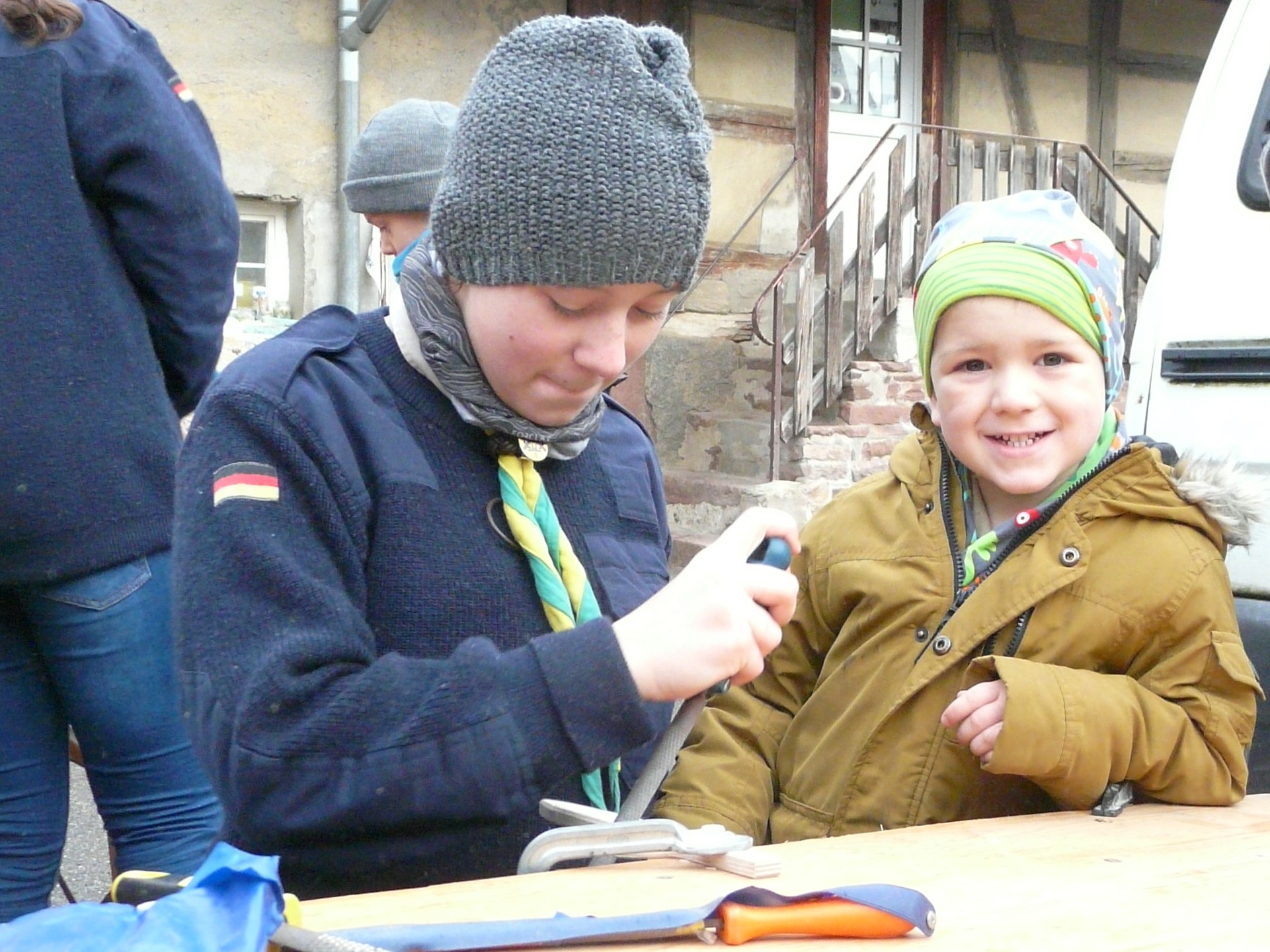 Kinder bearbeiten das Holzstück.