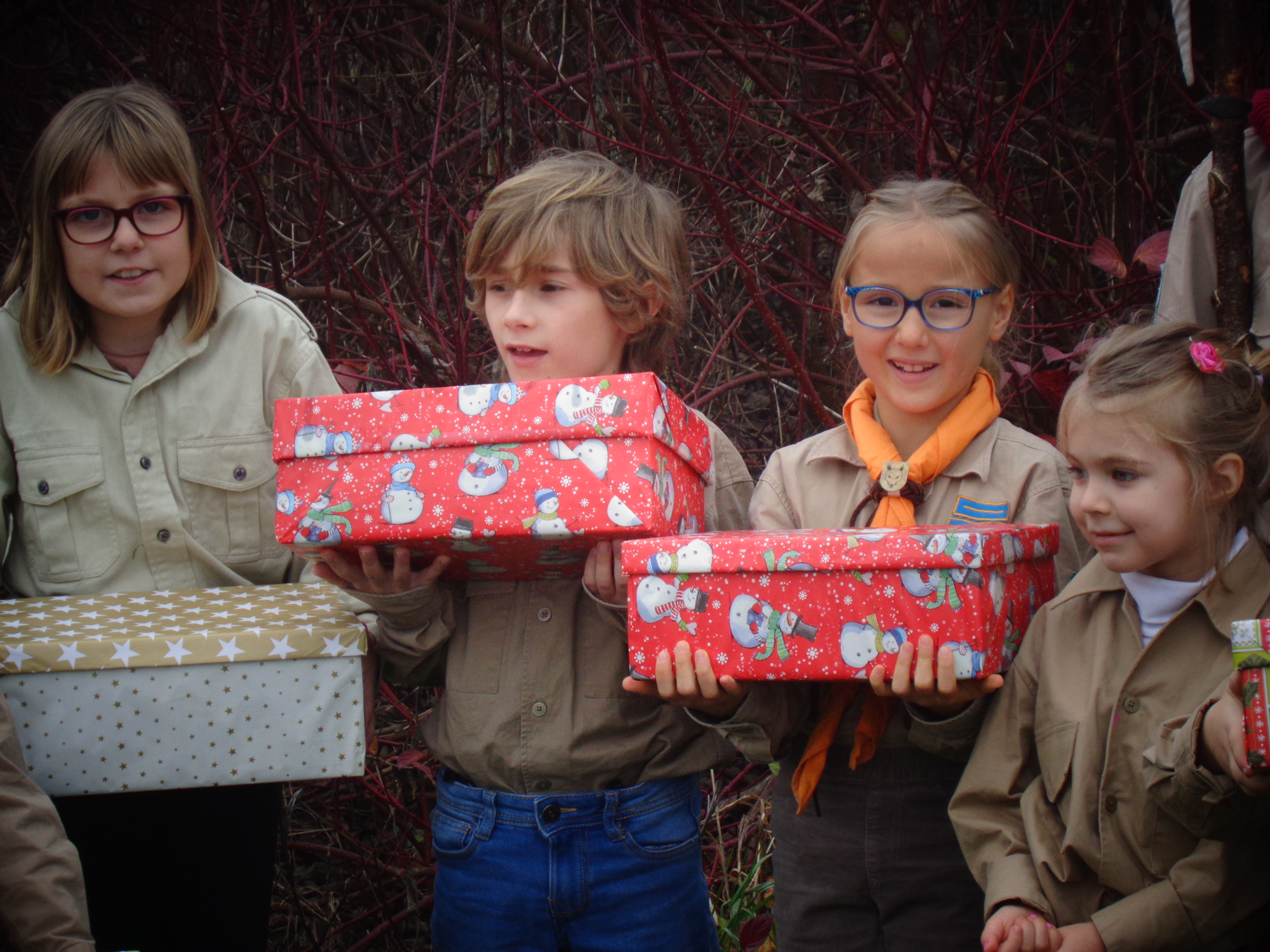 Zwei Wölflinge halten lachend zwei Päckchen in die Kamera